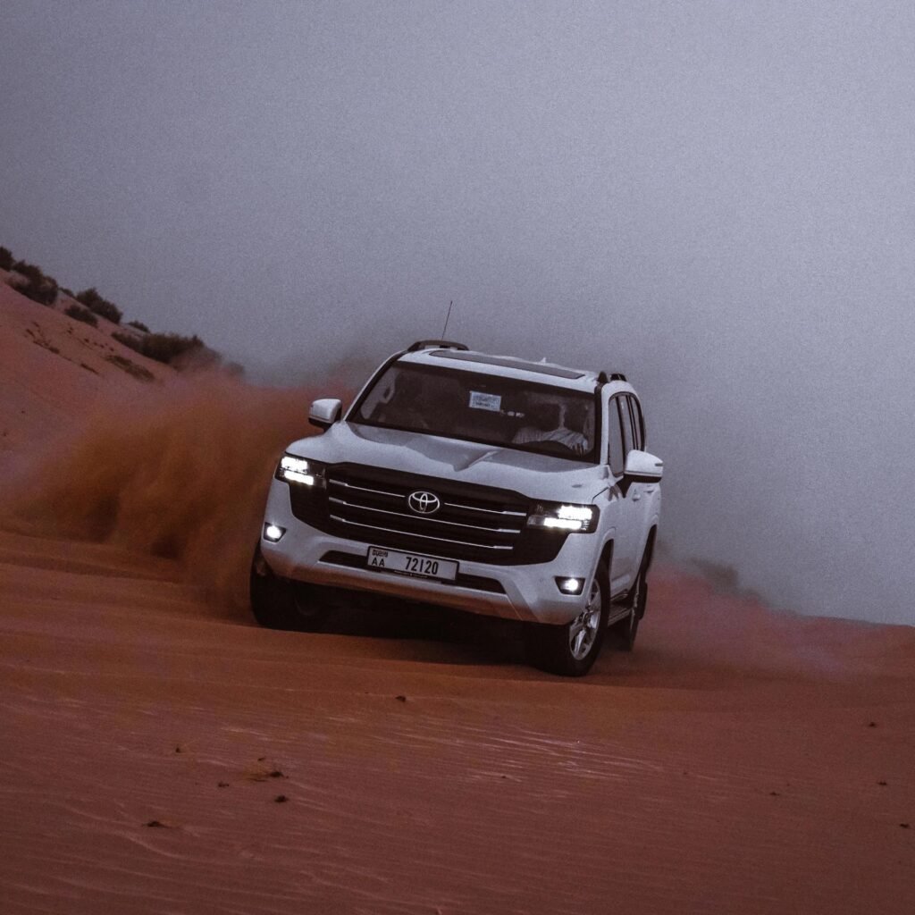 4x4 dune bashing kicking up sand at sunset in the Dubai desert